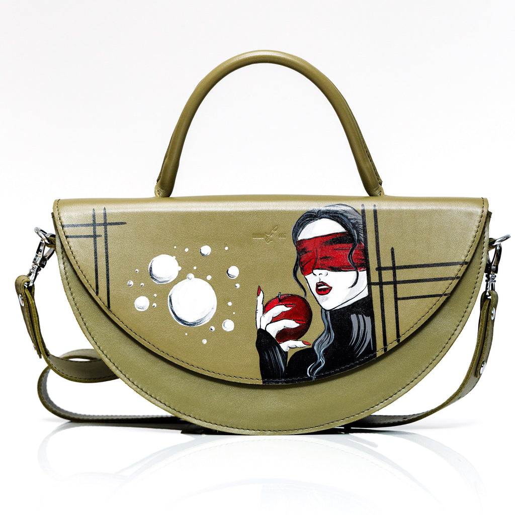 Green handbag with artistic design of a woman holding an apple